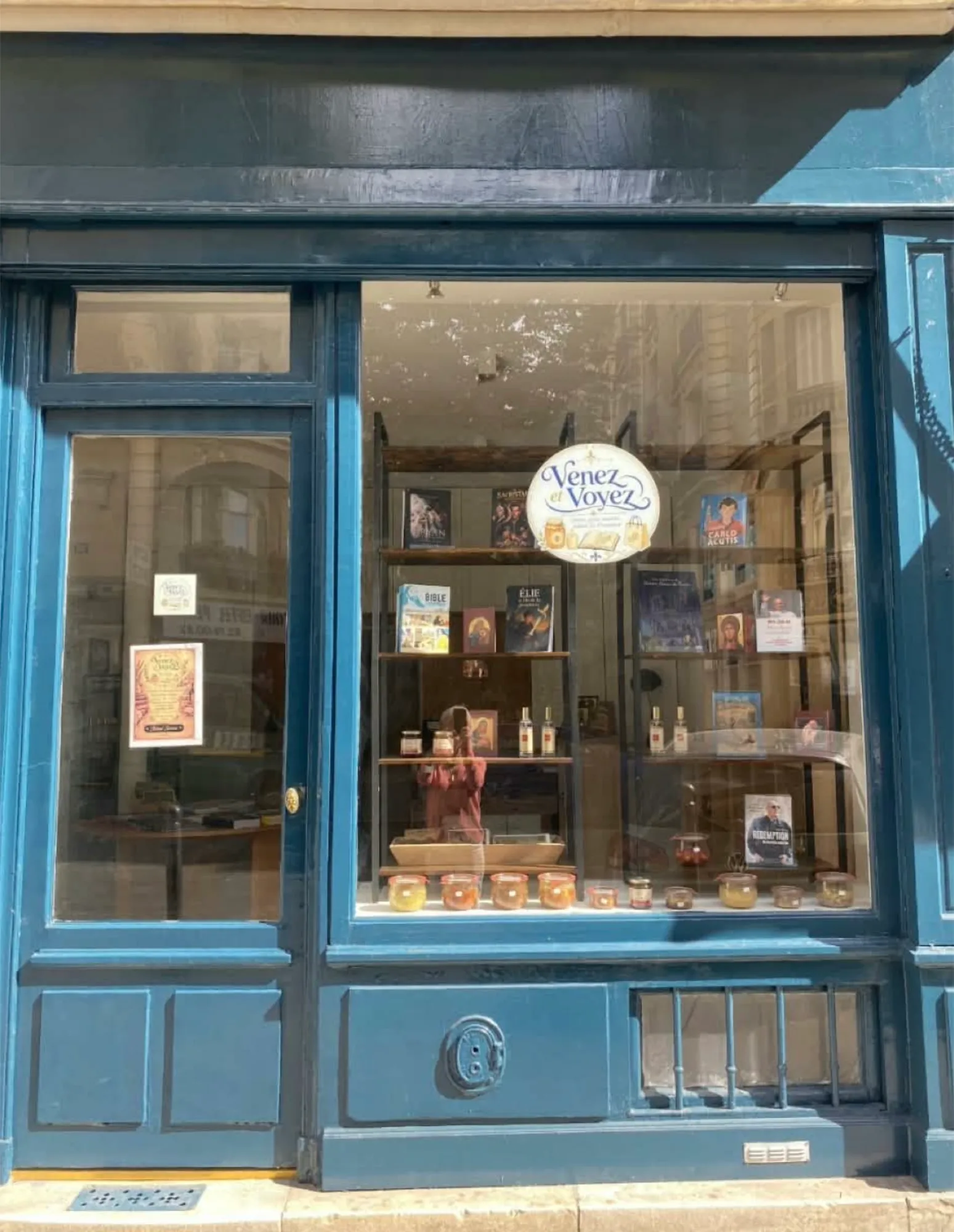 La devanture bleue de la librairie Venez et Voyez, avec ses livres et ses bougies en vitrine